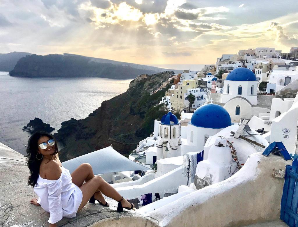 A girl during sunset with the famous blue domes