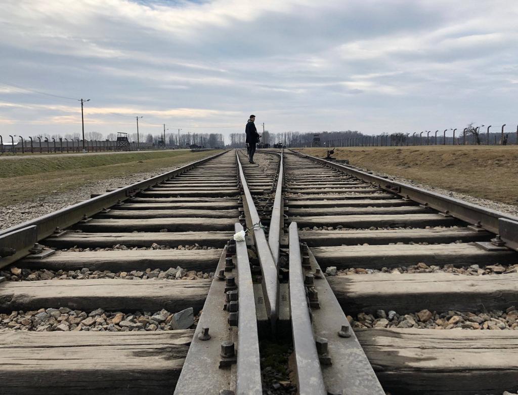 Taken during a moment of reflection at the most horrific Nazi extermination camp, Auschwitz, where millions of Jews were trained in one way by cattle car alive, but were murdered before being able to take the other side of the train tracks home