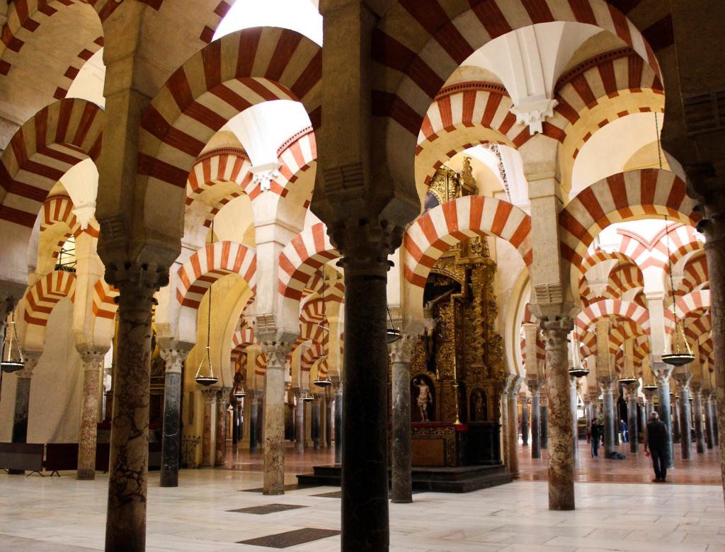 The arches of the beautiful Mezquita-Catedral of Córdoba, one of the best places to see the intersection of the three cultures (Islam, Christianity, and Judaism) that define the city's history.