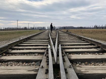 Taken during a moment of reflection at the most horrific Nazi extermination camp, Auschwitz, where millions of Jews were trained in one way by cattle car alive, but were murdered before being able to take the other side of the train tracks home