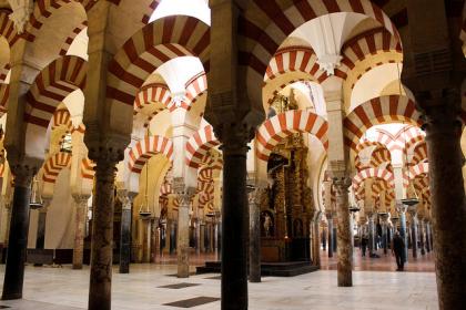 The arches of the beautiful Mezquita-Catedral of Córdoba, one of the best places to see the intersection of the three cultures (Islam, Christianity, and Judaism) that define the city's history.