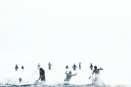 People running into the ocean in Sweden.