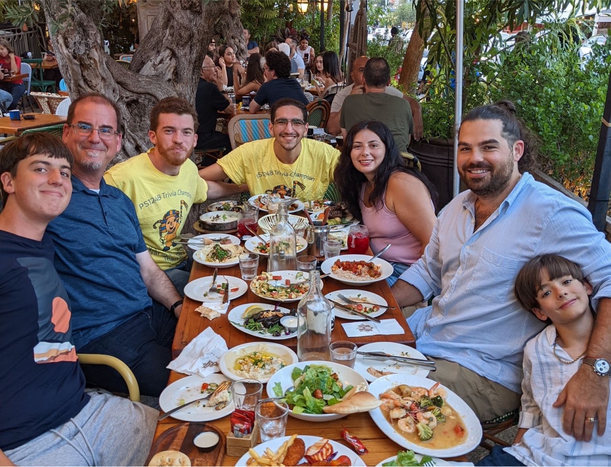 Friends sitting around a dinner table, smiling