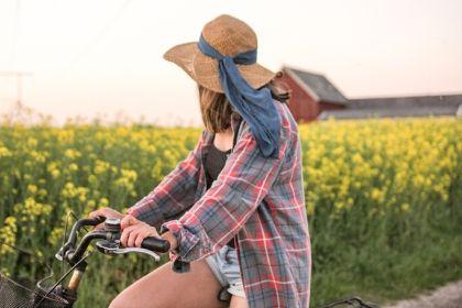 woman riding bike in field of flowers