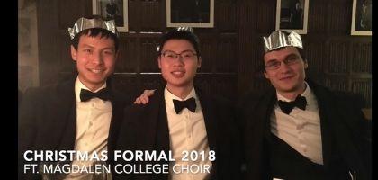 Image of three students posing in formal suits at Christmastime