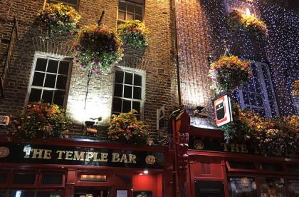 This part of Dublin is lit with twinkly lights, sprinkled with hanging flower planters, and covered in exposed brick. The red door frames add to the signature Dublin design of the city.